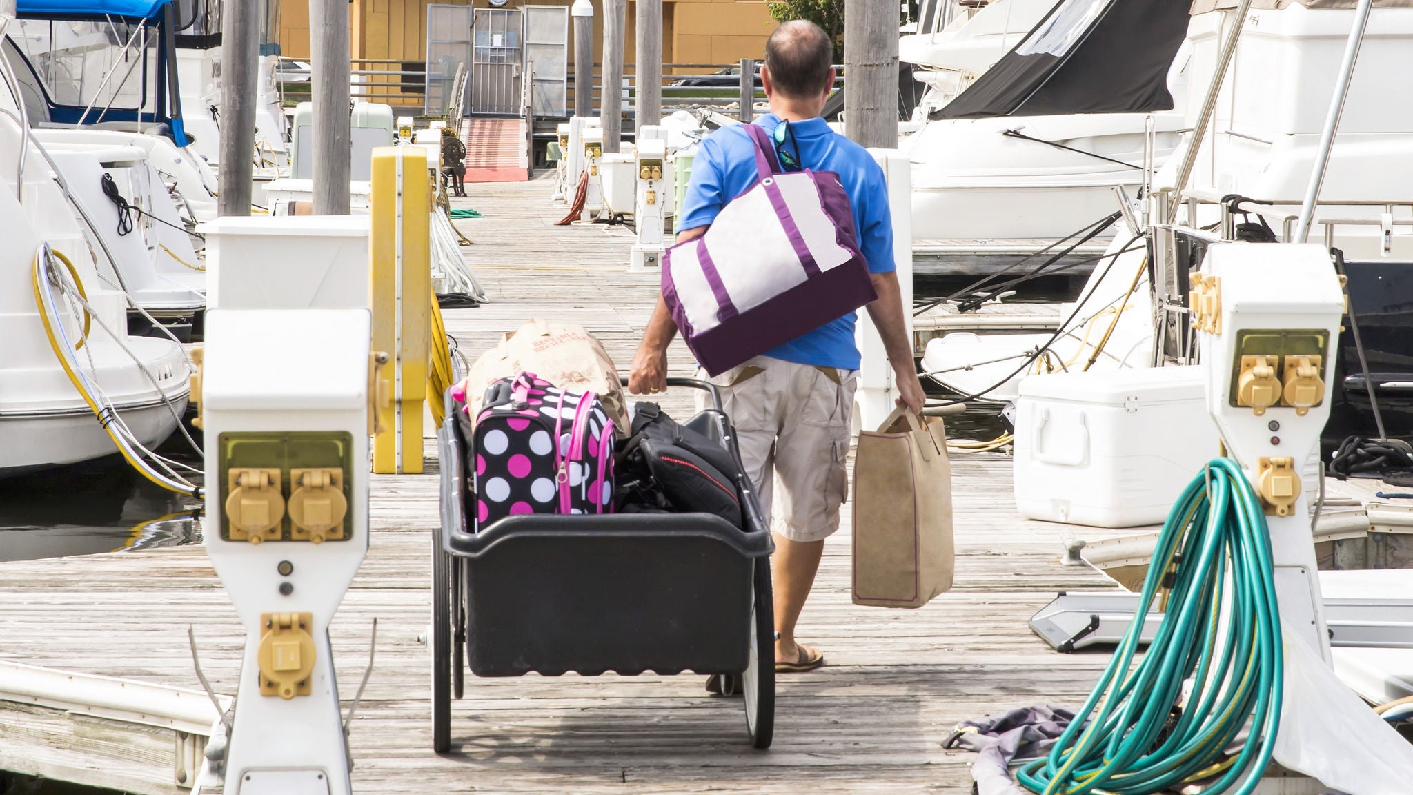 Man walking on dock next to marine power pedestals